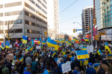 Toronto, Ontario Canada 6 Mart 2022: Toronto 'daki Rus konsolosluğu yakınlarında sarı ve mavi Ukrayna bayraklı göstericiler Ukrayna' daki savaş sırasında Ukrayna üzerindeki hava sahasını kapatma talebinde bulundu