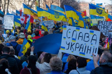 Toronto, Ontario Canada 6 Mart 2022: Toronto 'daki Rus konsolosluğu yakınlarında sarı ve mavi Ukrayna bayraklı göstericiler Ukrayna' daki savaş sırasında Ukrayna üzerindeki hava sahasını kapatma talebinde bulundu