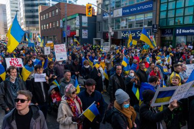 Toronto, Ontario Canada 6 Mart 2022: Toronto 'daki Rus konsolosluğu yakınlarında sarı ve mavi Ukrayna bayraklı göstericiler Ukrayna' daki savaş sırasında Ukrayna üzerindeki hava sahasını kapatma talebinde bulundu