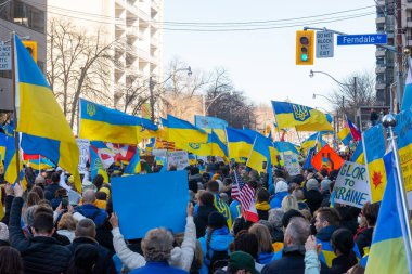 Toronto, Ontario Canada 6 Mart 2022: Toronto 'daki Rus konsolosluğu yakınlarında sarı ve mavi Ukrayna bayraklı göstericiler Ukrayna' daki savaş sırasında Ukrayna üzerindeki hava sahasını kapatma talebinde bulundu