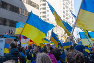 Toronto, Ontario, Kanada 6 Mart 2022: Toronto 'daki Rus konsolosluğu yakınlarında sarı ve mavi Ukrayna bayraklı göstericiler Ukrayna' daki savaş sırasında Ukrayna üzerindeki hava sahasını kapatma talebinde bulundu