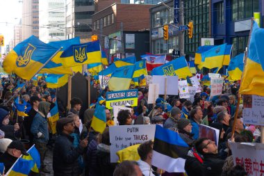 Toronto, Ontario, Kanada 6 Mart 2022: Toronto 'daki Rus konsolosluğu yakınlarında sarı ve mavi Ukrayna bayraklı göstericiler Ukrayna' daki savaş sırasında Ukrayna üzerindeki hava sahasını kapatma talebinde bulundu