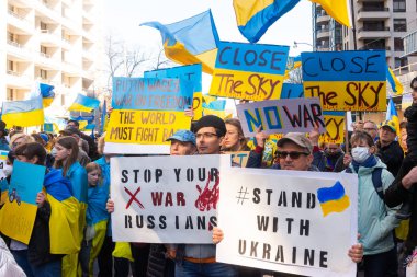 Toronto, Ontario, Kanada 6 Mart 2022: Toronto 'daki Rus konsolosluğu yakınlarında sarı ve mavi Ukrayna bayraklı göstericiler Ukrayna' daki savaş sırasında Ukrayna üzerindeki hava sahasını kapatma talebinde bulundu