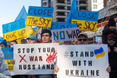Toronto, Ontario, Kanada 6 Mart 2022: Toronto 'daki Rus konsolosluğu yakınlarında sarı ve mavi Ukrayna bayraklı göstericiler Ukrayna' daki savaş sırasında Ukrayna üzerindeki hava sahasını kapatma talebinde bulundu