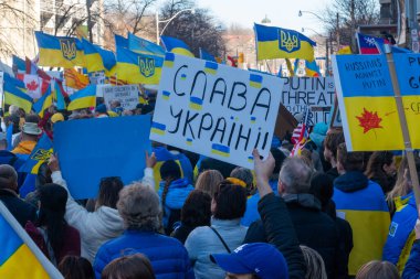 Toronto, Ontario, Kanada 6 Mart 2022: Toronto 'daki Rus konsolosluğu yakınlarında sarı ve mavi Ukrayna bayraklı göstericiler Ukrayna' daki savaş sırasında Ukrayna üzerindeki hava sahasını kapatma talebinde bulundu