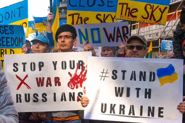 Toronto, Ontario, Kanada 6 Mart 2022: Toronto 'daki Rus konsolosluğu yakınlarında sarı ve mavi Ukrayna bayraklı göstericiler Ukrayna' daki savaş sırasında Ukrayna üzerindeki hava sahasını kapatma talebinde bulundu