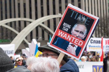 Toronto, ON, Kanada 10 Nisan 2022: Ukraynalıların soykırımını durdurmak için düzenlenen Ukrayna Kanada Kongresi mitinginde Ukrayna şehir merkezindeki Nathan Phillips Meydanı 'nda pankart ve bayraklı protestocular. Putin ve Rus ordusu Uk 'u yok etmek istiyor.