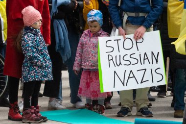 Toronto, ON, Kanada 10 Nisan 2022: Ukraynalıların soykırımını durdurmak için düzenlenen Ukrayna Kanada Kongresi mitinginde Ukrayna şehir merkezindeki Nathan Phillips Meydanı 'nda pankart ve bayraklı protestocular. Putin ve Rus ordusu Uk 'u yok etmek istiyor.