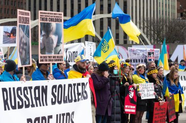 Toronto, ON, Kanada 10 Nisan 2022: Ukraynalıların soykırımını durdurmak için düzenlenen Ukrayna Kanada Kongresi mitinginde Ukrayna şehir merkezindeki Nathan Phillips Meydanı 'nda pankart ve bayraklı protestocular. Putin ve Rus ordusu Uk 'u yok etmek istiyor.