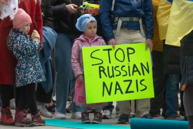 Toronto, ON, Kanada 10 Nisan 2022: Ukraynalıların soykırımını durdurmak için düzenlenen Ukrayna Kanada Kongresi mitinginde Ukrayna şehir merkezindeki Nathan Phillips Meydanı 'nda pankart ve bayraklı protestocular. Putin ve Rus ordusu Uk 'u yok etmek istiyor.