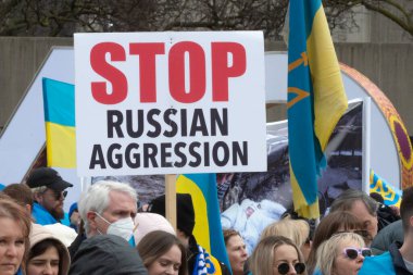 Toronto, ON, Kanada 10 Nisan 2022: Ukraynalıların soykırımını durdurmak için düzenlenen Ukrayna Kanada Kongresi mitinginde Ukrayna şehir merkezindeki Nathan Phillips Meydanı 'nda pankart ve bayraklı protestocular. Putin ve Rus ordusu Uk 'u yok etmek istiyor.