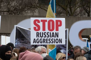 Toronto, ON, Kanada 10 Nisan 2022: Ukraynalıların soykırımını durdurmak için düzenlenen Ukrayna Kanada Kongresi mitinginde Ukrayna şehir merkezindeki Nathan Phillips Meydanı 'nda pankart ve bayraklı protestocular. Putin ve Rus ordusu Uk 'u yok etmek istiyor.