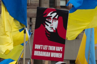 Toronto, ON, Kanada 10 Nisan 2022: Ukraynalıların soykırımını durdurmak için düzenlenen Ukrayna Kanada Kongresi mitinginde Ukrayna şehir merkezindeki Nathan Phillips Meydanı 'nda pankart ve bayraklı protestocular. Putin ve Rus ordusu Uk 'u yok etmek istiyor.
