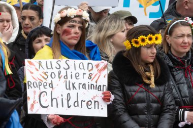 Toronto, ON, Kanada 10 Nisan 2022: Ukraynalıların soykırımını durdurmak için düzenlenen Ukrayna Kanada Kongresi mitinginde Ukrayna şehir merkezindeki Nathan Phillips Meydanı 'nda pankart ve bayraklı protestocular. Putin ve Rus ordusu Uk 'u yok etmek istiyor.