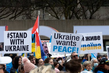 Toronto, ON, Kanada 10 Nisan 2022: Ukraynalıların soykırımını durdurmak için düzenlenen Ukrayna Kanada Kongresi mitinginde Ukrayna şehir merkezindeki Nathan Phillips Meydanı 'nda pankart ve bayraklı protestocular. Putin ve Rus ordusu Uk 'u yok etmek istiyor.