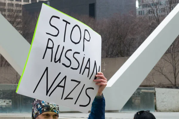 Toronto, ON, Kanada 10 Nisan 2022: Ukraynalıların soykırımını durdurmak için düzenlenen Ukrayna Kanada Kongresi mitinginde Ukrayna şehir merkezindeki Nathan Phillips Meydanı 'nda pankart ve bayraklı protestocular. Putin ve Rus ordusu Uk 'u yok etmek istiyor.