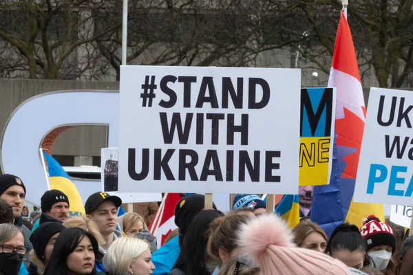 Toronto, ON, Kanada 10 Nisan 2022: Ukraynalıların soykırımını durdurmak için düzenlenen Ukrayna Kanada Kongresi mitinginde Ukrayna şehir merkezindeki Nathan Phillips Meydanı 'nda pankart ve bayraklı protestocular. Putin ve Rus ordusu Uk 'u yok etmek istiyor.