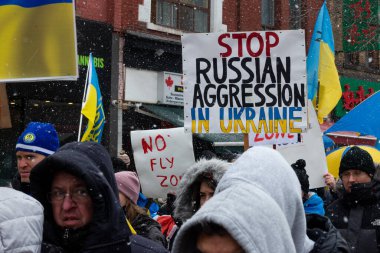 Toronto, ON, Kanada 10 Nisan 2022: Ukraynalıların soykırımını durdurmak amacıyla düzenlenen miting sırasında Ukrayna şehir merkezinde pankartlı ve Ukrayna bayraklı protestocular.