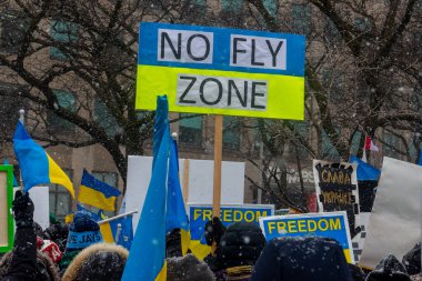 Toronto, ON, Kanada 10 Nisan 2022: Ukraynalıların soykırımını durdurmak amacıyla düzenlenen miting sırasında Ukrayna şehir merkezinde pankartlı ve Ukrayna bayraklı protestocular.