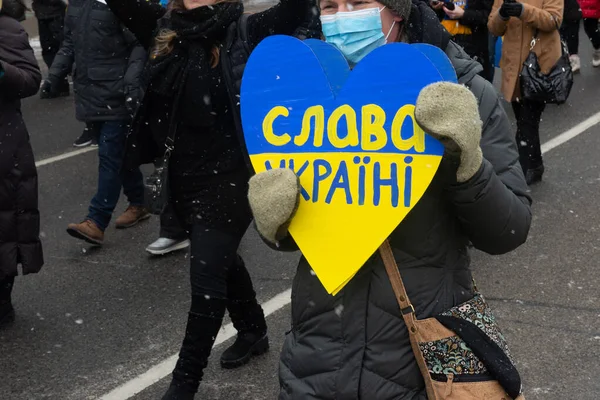 Toronto, ON, Kanada 10 Nisan 2022: Ukraynalıların soykırımını durdurmak amacıyla düzenlenen miting sırasında Ukrayna şehir merkezinde pankartlı ve Ukrayna bayraklı protestocular.