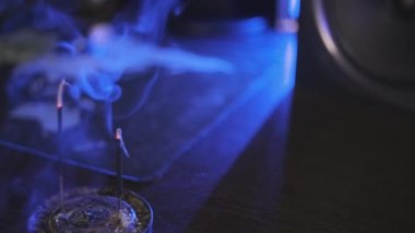 Aroma masaya yapışıyor. Tütsü tütsüleri karanlık odayı tütsü kokusuyla doldurur. Sadece kokuyu içine çek ve rahatla. Mavimsi ışıkta dumanı yaymak.