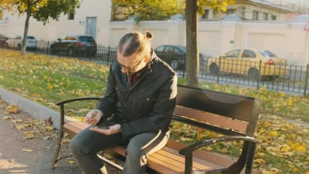 Fakir Bir Adam Eski Giysiler Gözlüklerle Parktaki Bankta Oturmuş Avucundaki — Stok video