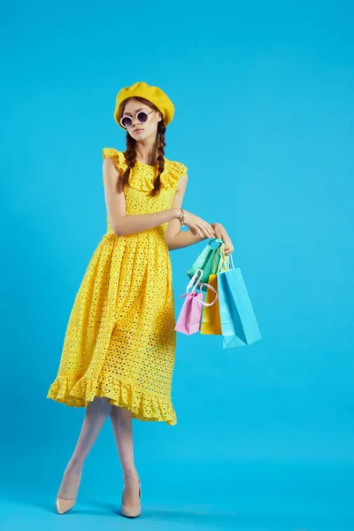 Glad kvinna i en gul hatt Shopaholic mode stil studio modell — Stockfoto