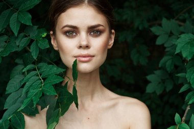 Gülümseyen kadın cilt bakımı çıplak omuzlar yeşil yapraklar doğa modeli