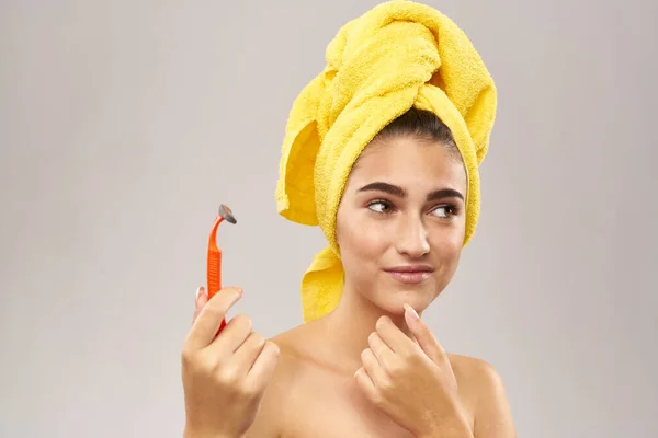 Bela mulher com uma toalha amarela em sua cabeça de barbear — Fotografia de Stock