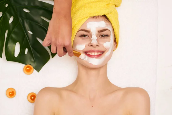 Vrolijk vrouw met een handdoek op mijn hoofd huidverzorging licht achtergrond — Stockfoto