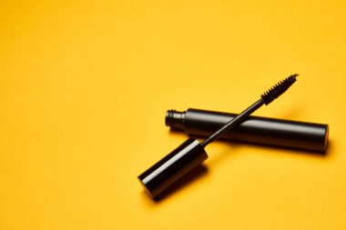 Kozmetik maskara süsleme aksesuarları sarı arkaplan