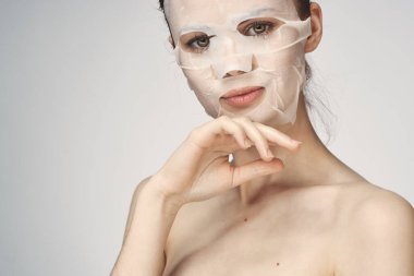 Çıplak omuzlu kadın maske takıyor.