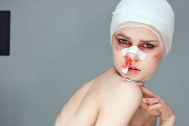 Kadın hasta tamponu burnunda ve yüzü kan içinde.