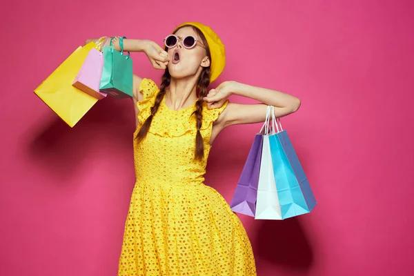 Mooie vrouw geel jurk winkelen leuk geïsoleerde achtergrond — Stockfoto