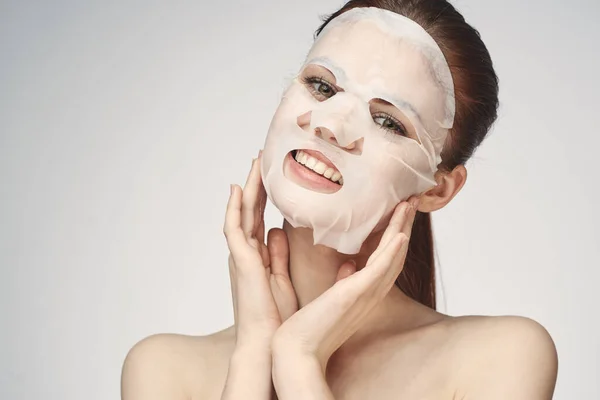 Wanita emosional masker wajah kosmetik close-up latar belakang cahaya — Stok Foto