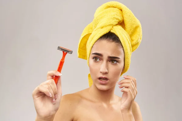 Mulher bonita com uma toalha amarela em sua cabeça de barbear — Fotografia de Stock