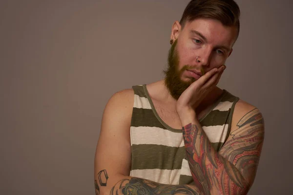 Homme à la mode avec des tatouages sur ses bras style coiffure studio confiance en soi — Photo