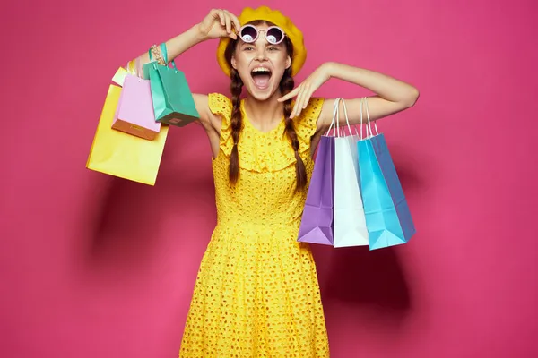 Весела жінка в жовтому капелюсі Shopaholic модний стиль рожевий фон — стокове фото