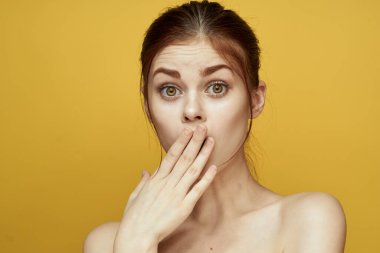 Güzel kadın çıplak omuzlar ve açık ten sarısı bir arka plan.