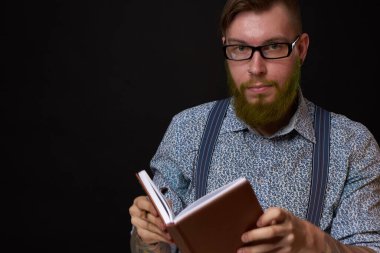 Elinde not defteri olan gözlüklü bir adam profesyonel ofisi eğitiyor.