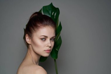 çekici bir kadın, çıplak omuzlar, kırmızı dudaklar, koyu arka plan.