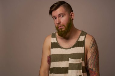 Kollarında dövmeleri olan yakışıklı bir adam. Saç stili duyguları var.