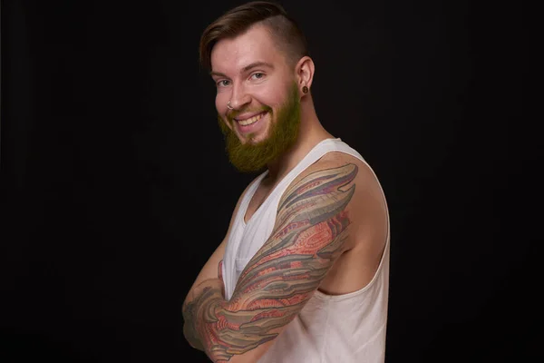 Hombre barbudo con estilo en una camiseta blanca con tatuajes en sus brazos de moda — Foto de Stock