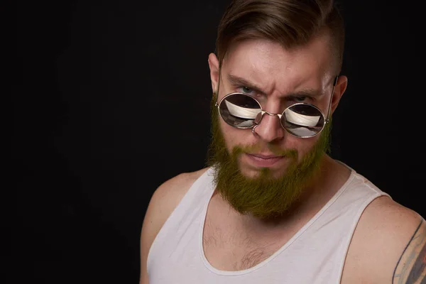 Hombre guapo con tatuajes en sus brazos gafas de sol de moda fondo oscuro —  Fotos de Stock