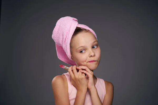 Ragazza con un asciugamano sulla testa cosmetici cura della pelle sfondo grigio — Foto Stock