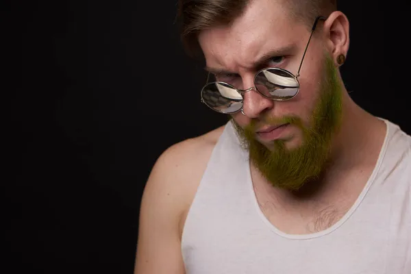 Przystojny mężczyzna z tatuażami na ramionach moda okulary przeciwsłoneczne ciemne tło — Zdjęcie stockowe