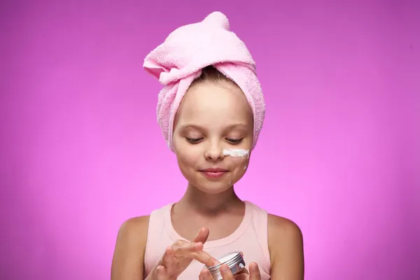 Κορίτσι με μια πετσέτα στο κεφάλι διακόσμηση καλλυντικών close-up μωβ φόντο — Φωτογραφία Αρχείου