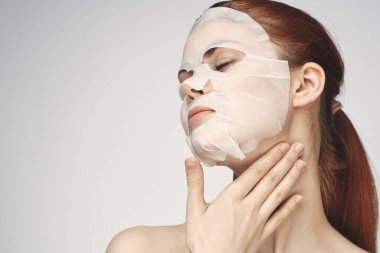 Güzel bir kadın çıplak omuzlarıyla maske takar.