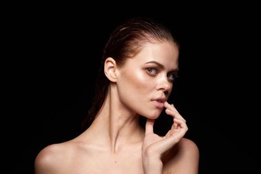 Güzel bir kadın, çıplak omuzlar temiz cilt, ıslak saçlar koyu arkaplan