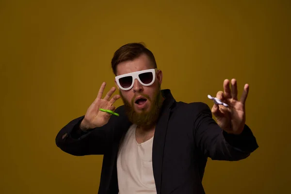 Man wearing sunglasses spinner in hands fashion posing black jacket — Stock Photo, Image